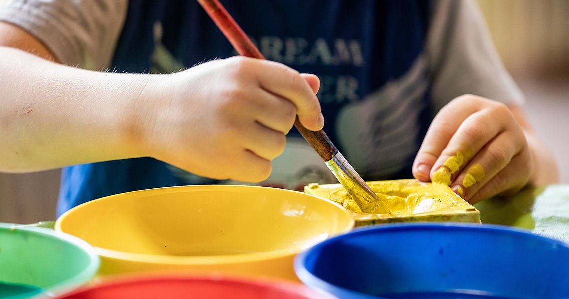 Kind malt mit bunten Wasserfarben