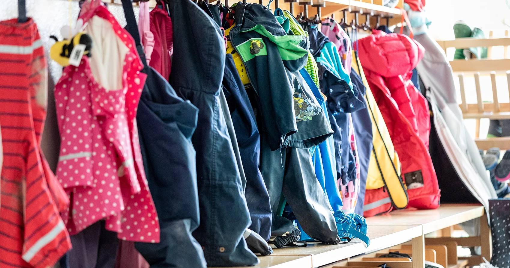 Garderobe mit bunten Kinderjacken